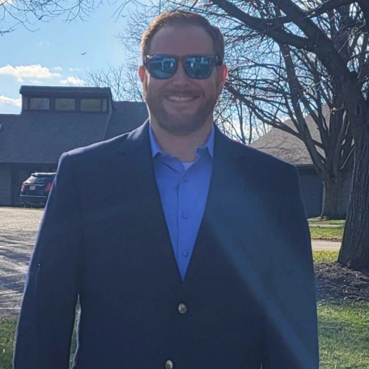 Paul Gover standing outdoors in a blue suit and sunglasses