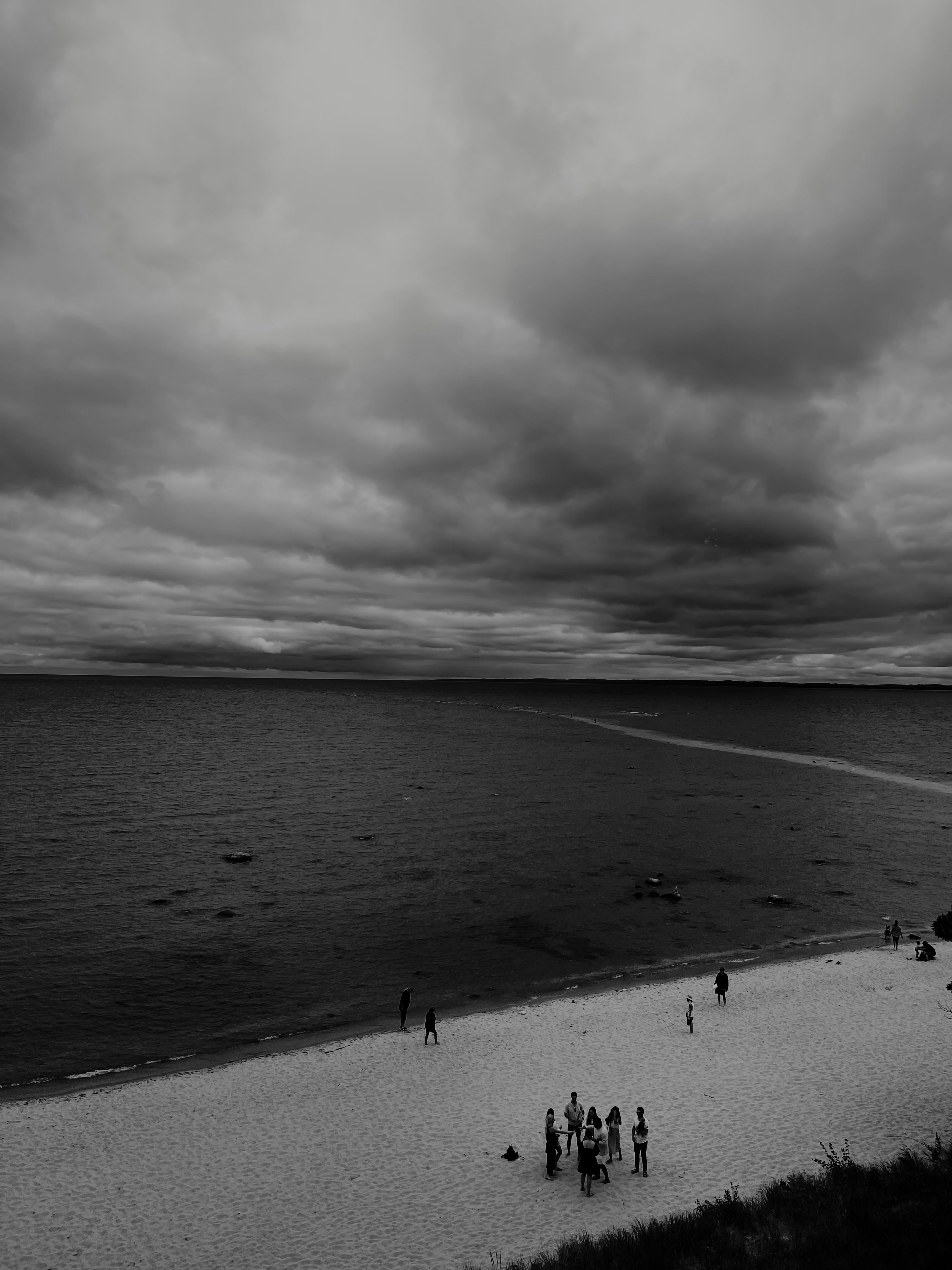 Quiet Before the Storm — elevated beach view with dramatic storm clouds, small figures on white sand below, fine art black and white landscape by Craig Moyers, Lake Michigan photographer