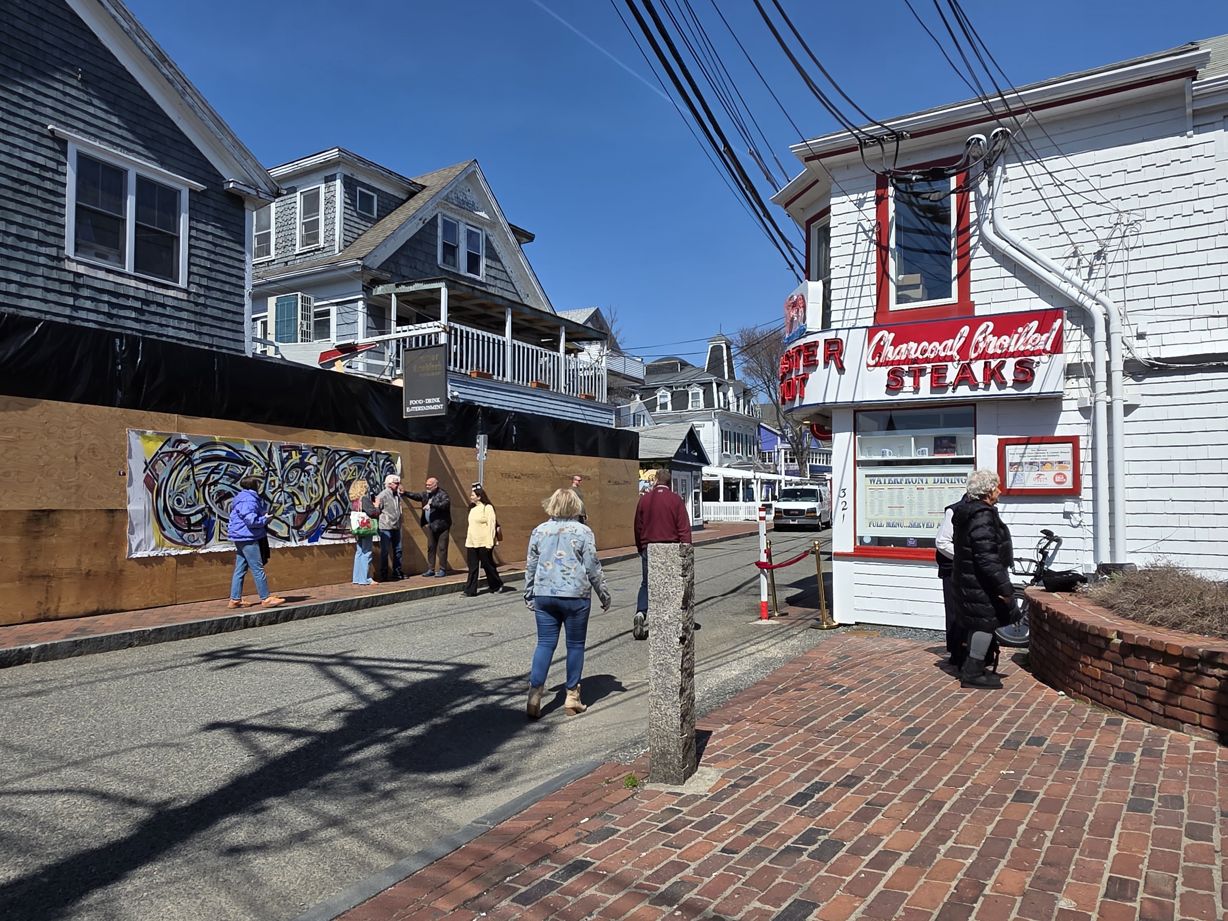 People stopping on Commercial Street to look at Baransky on the construction boards