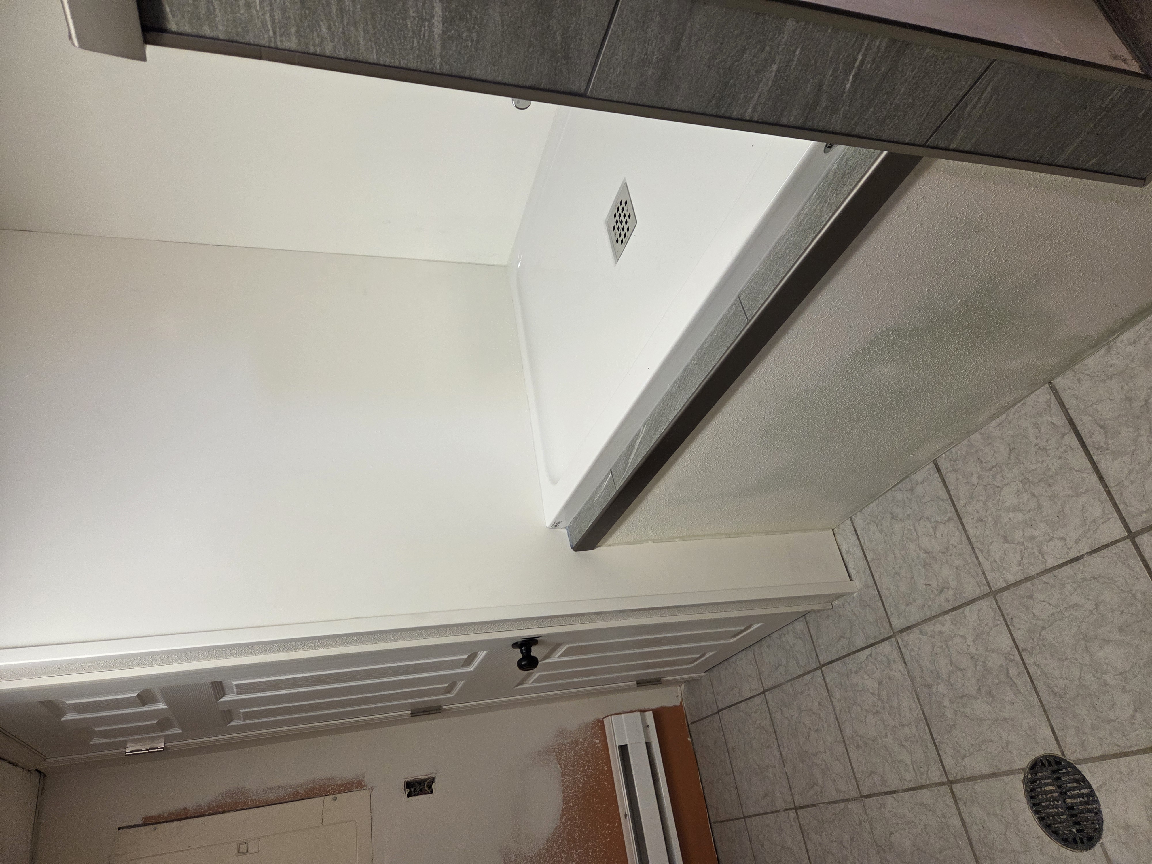 Room context — full alcove build with elevated pan, half-wall, and tile cap