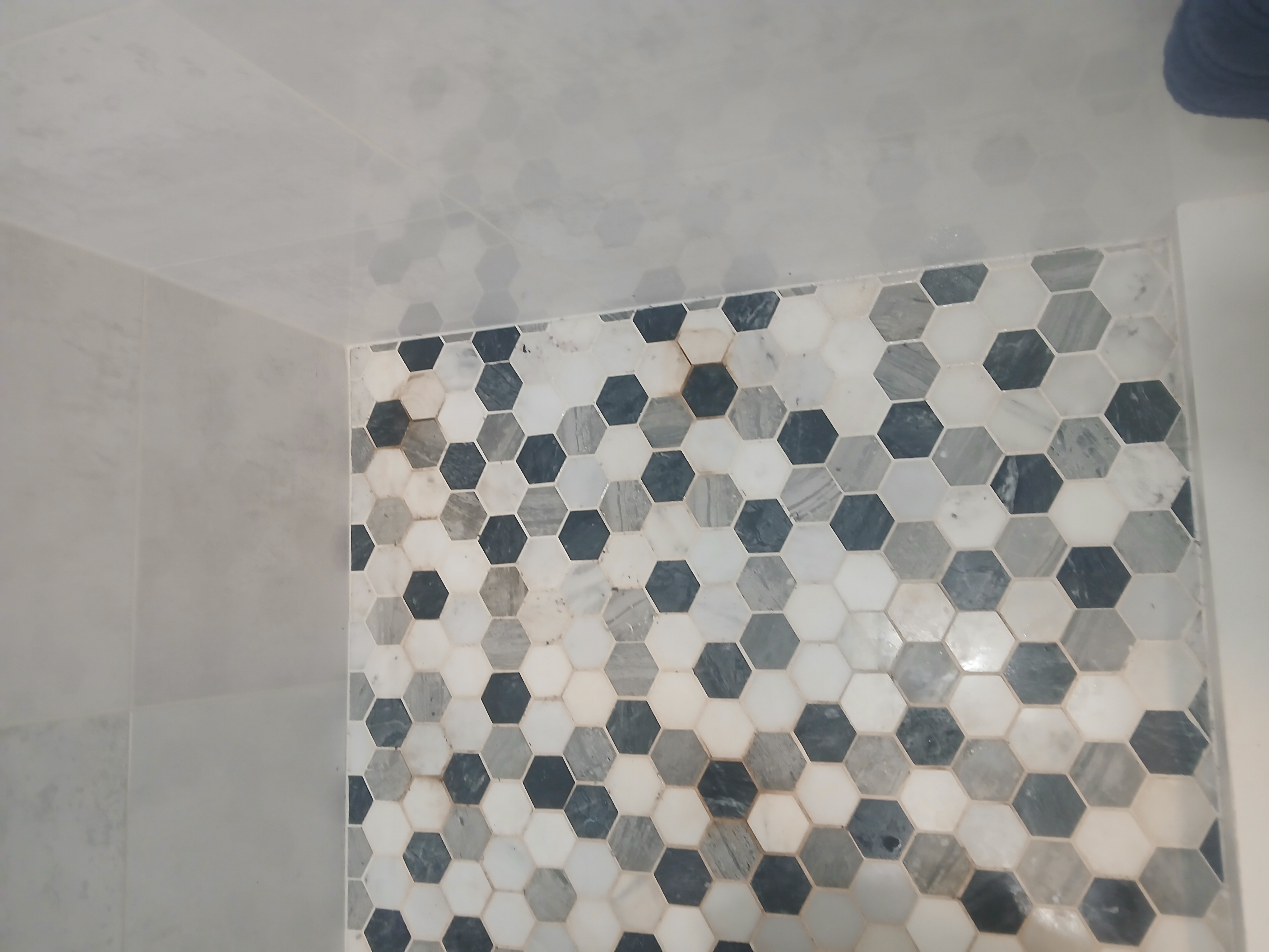 Shower floor after — clean grout, fresh corners