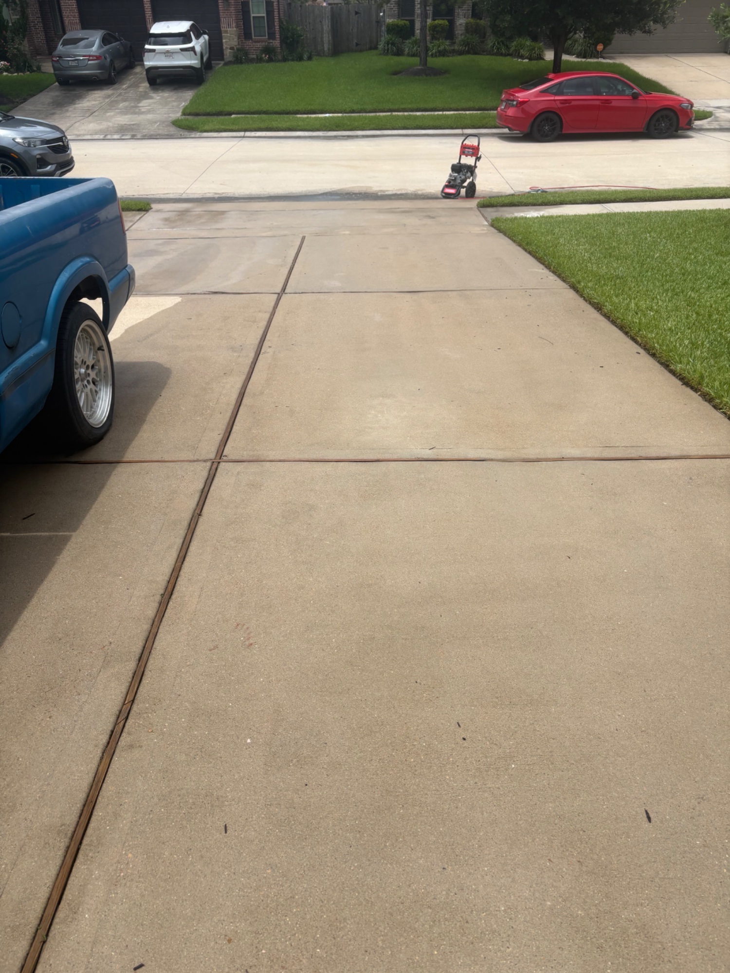 Driveway after pressure washing — clean, bright concrete with pressure washer