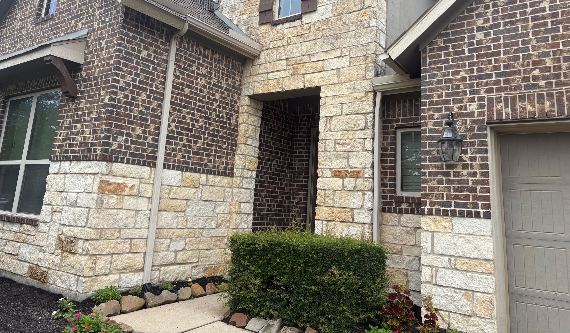 Stone and brick home after washing — clean stone and freshly restored exterior
