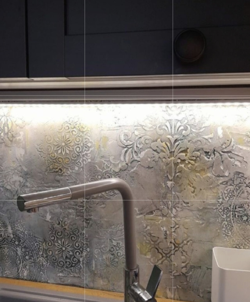 Decorative plaster kitchen backsplash behind navy cabinets