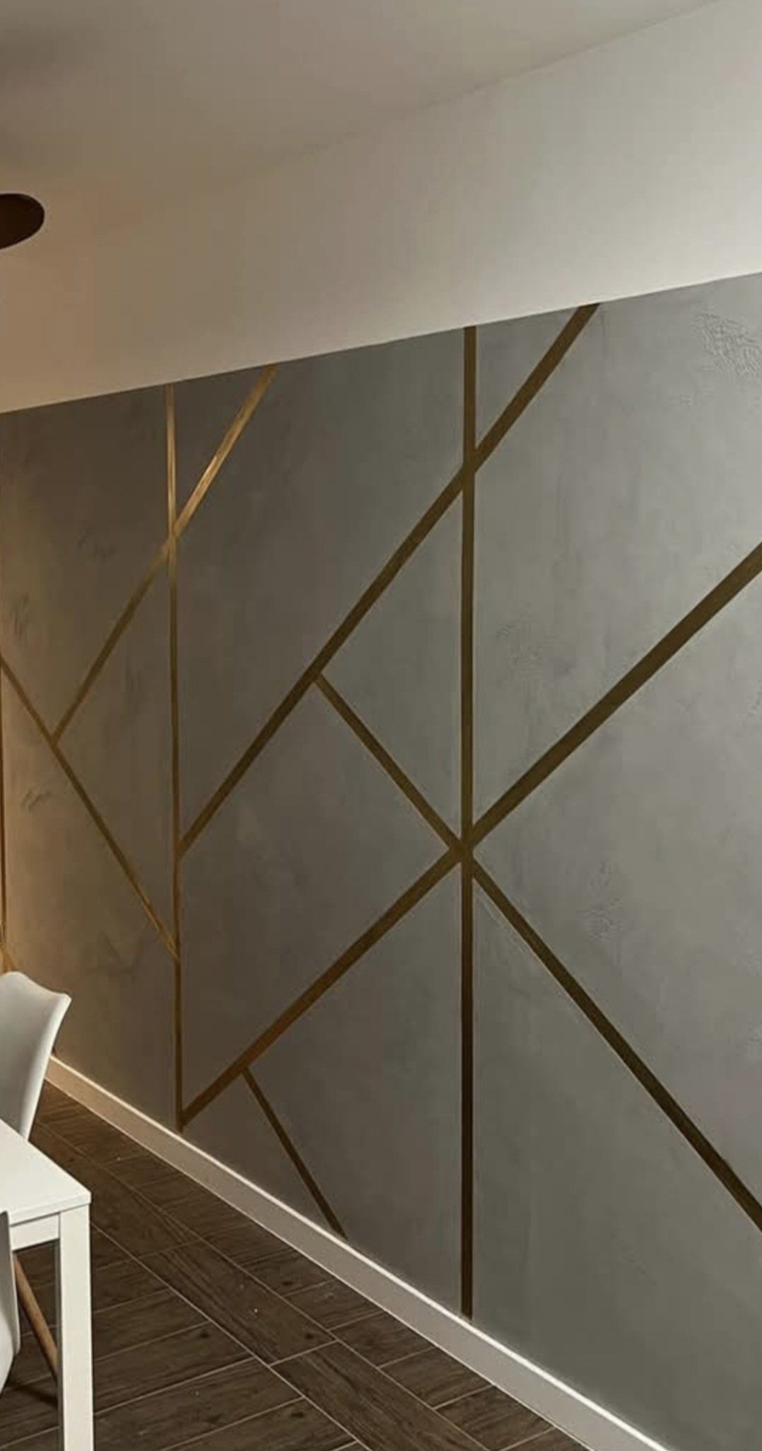 Gray Venetian plaster with bold brass and gold geometric lines