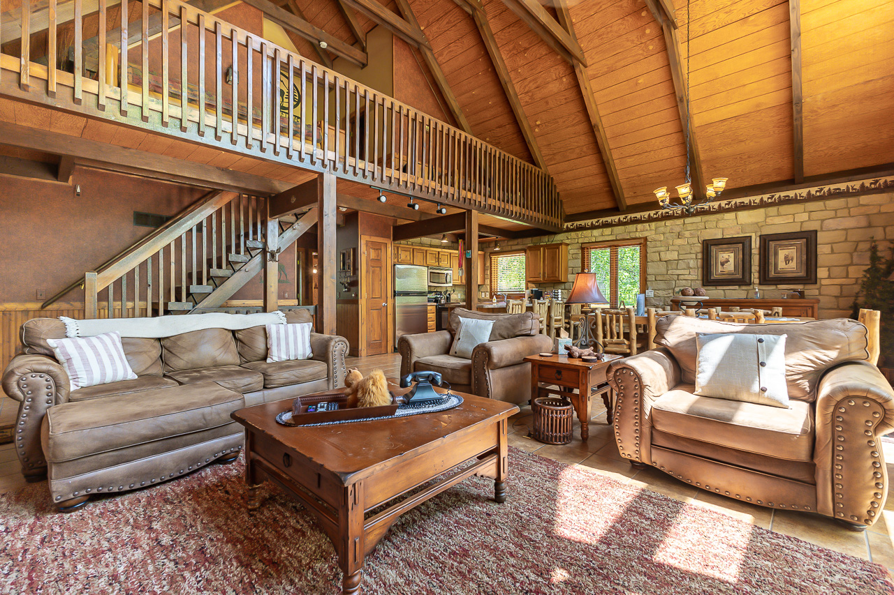 Living Room with leather sofas, stone wall, and open floor plan