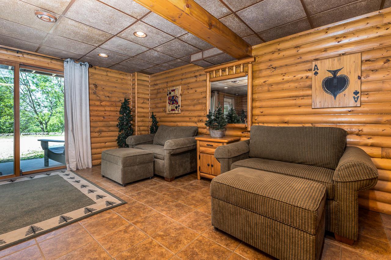 Lower Level Lounge with log walls, comfortable sofas, and sliding glass door