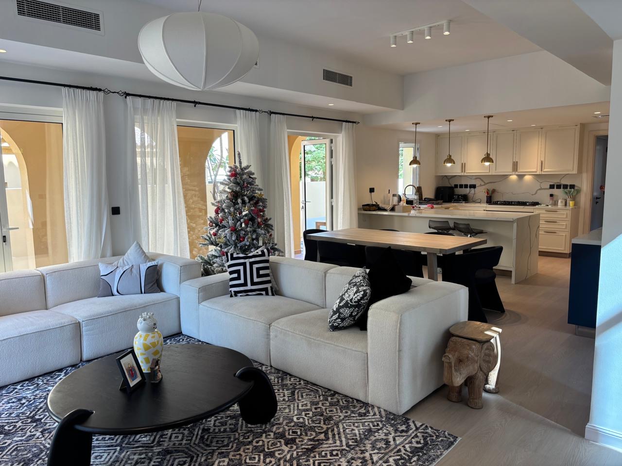 Living room with sectional sofa, pendant lights, area rug, coffee table, and dining set