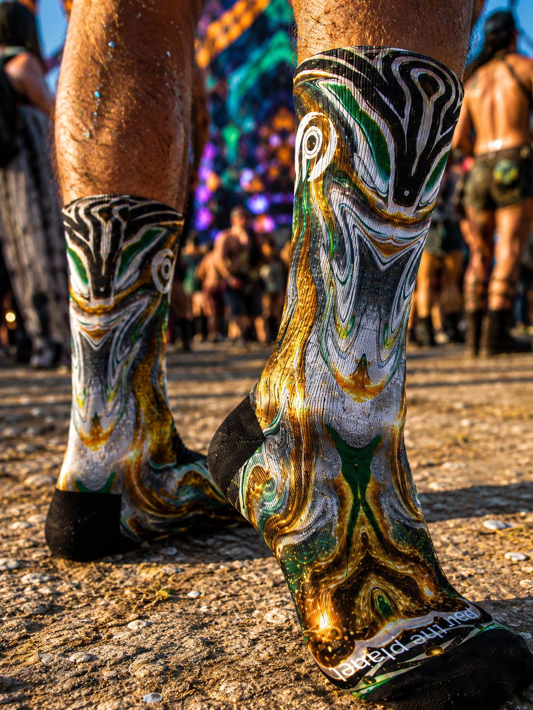 Gold and green swirl festival sock — lifestyle shot at golden hour