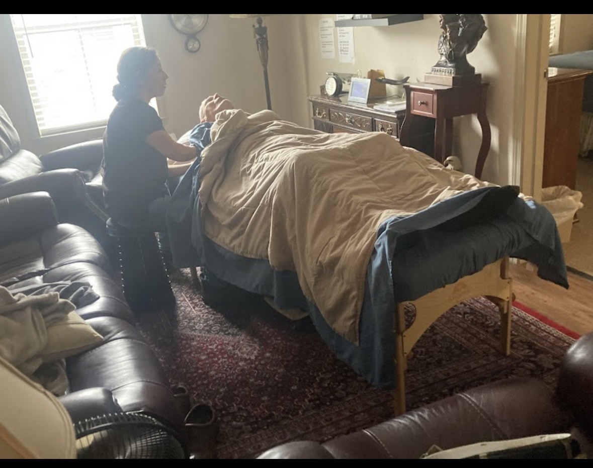 Founder giving massage to a 94-year-old Navy Captain in his living room