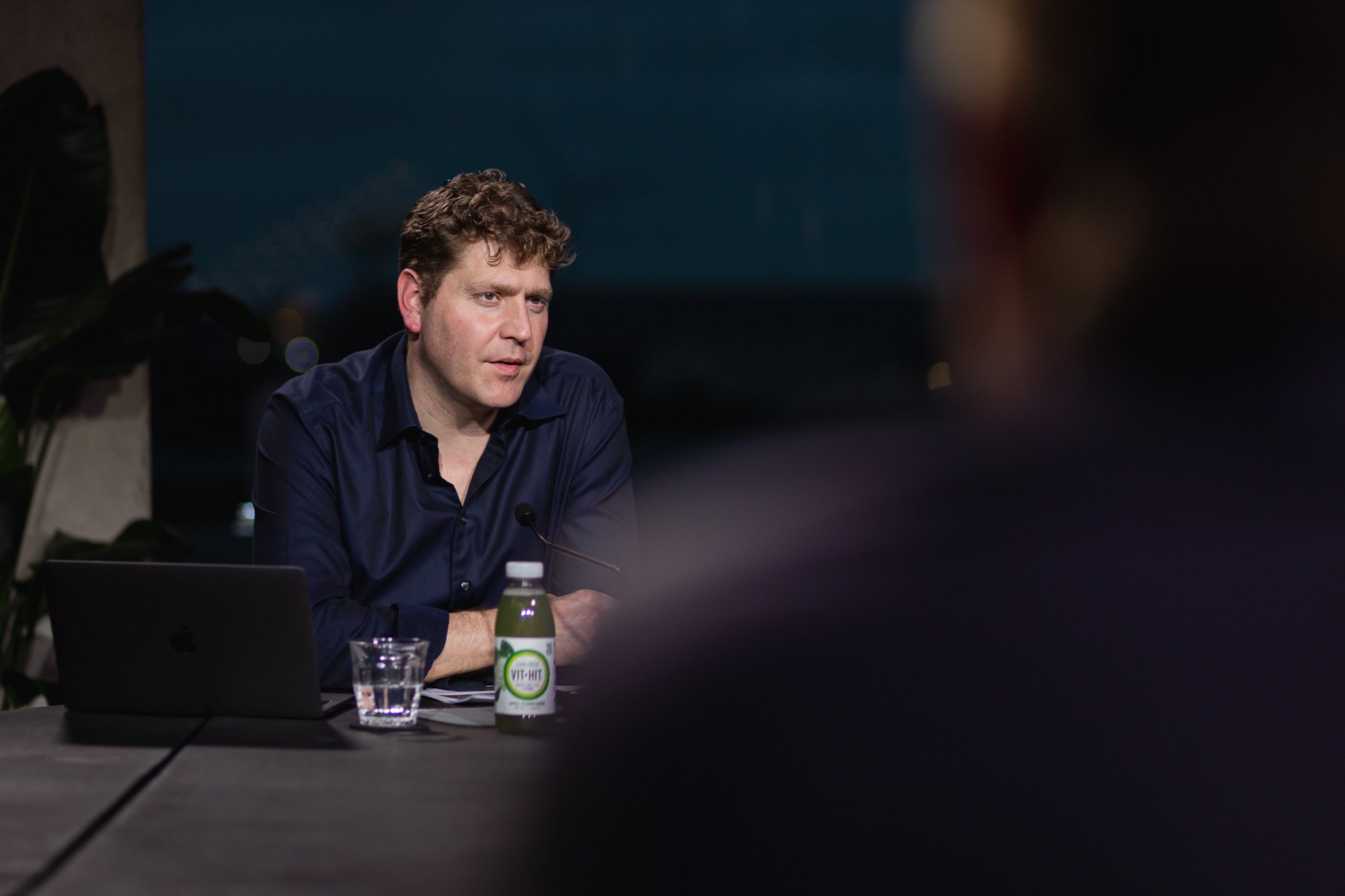Host close-up at the studio desk