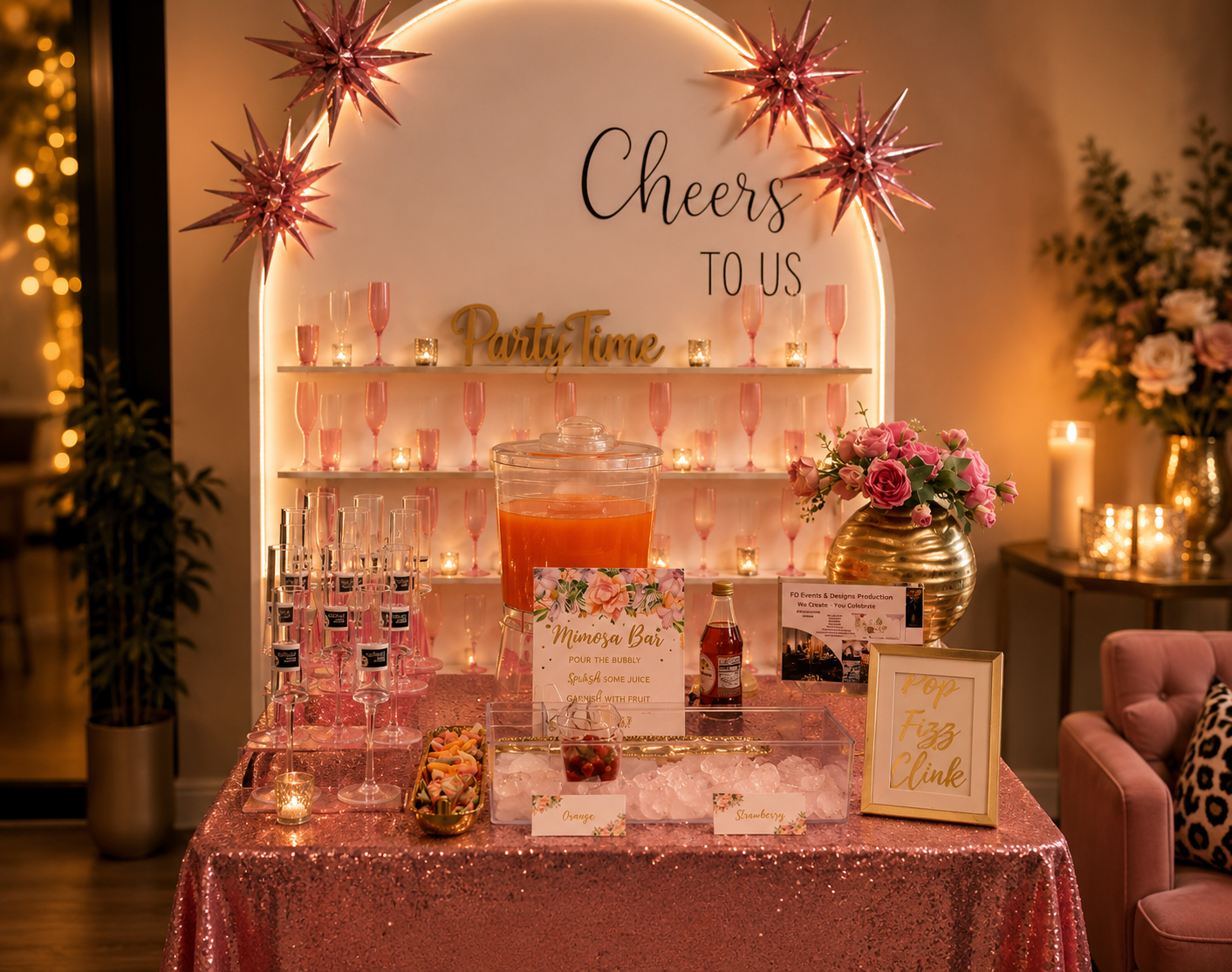 Mimosa bar with pink sequin table, champagne wall, and Cheers to Us arch
