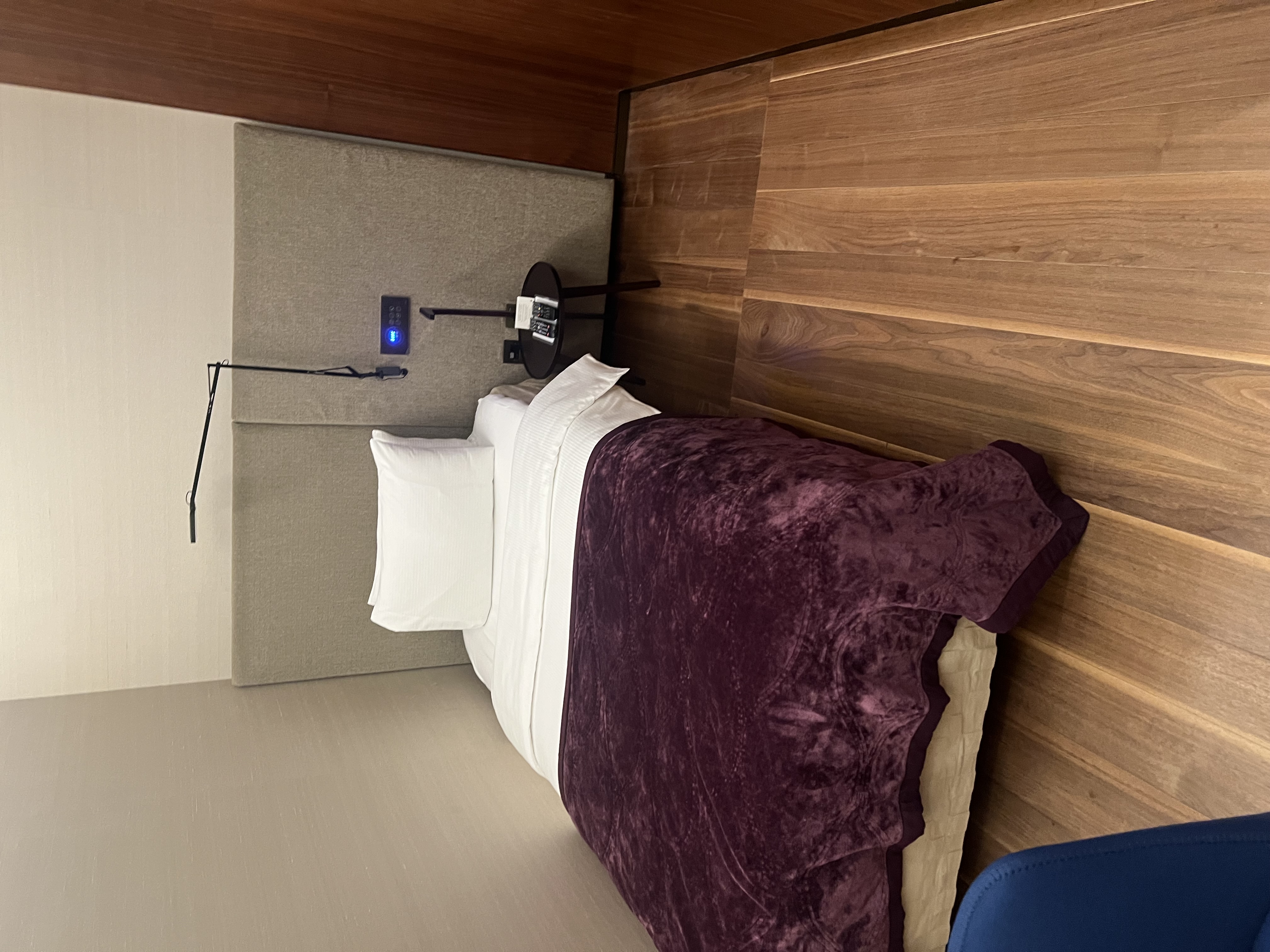 Private nap room with a full bed and ambient lighting inside Al Safwa First Class Lounge Doha