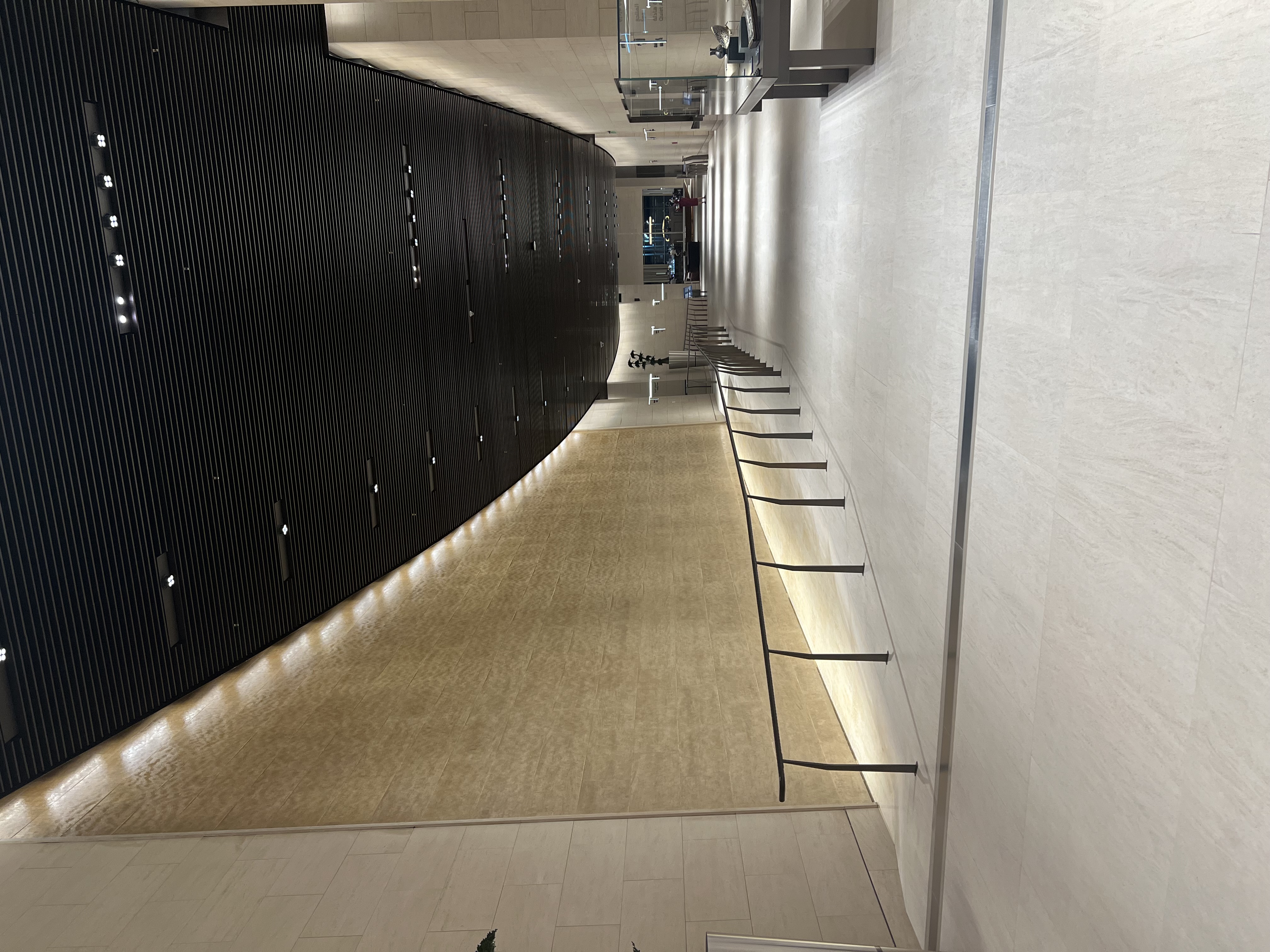 Grand hallway with curved sandstone walls inside Al Safwa First Class Lounge at Hamad International Airport Doha