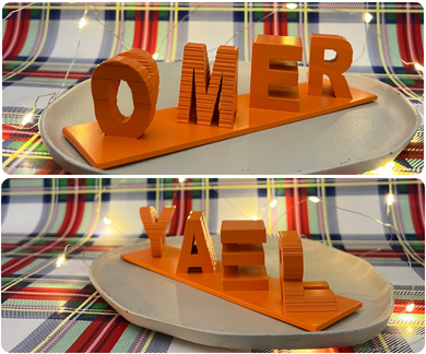 Dual Name Table Piece showing OMER from one angle and YAEL from another, displayed on a holiday table setting
