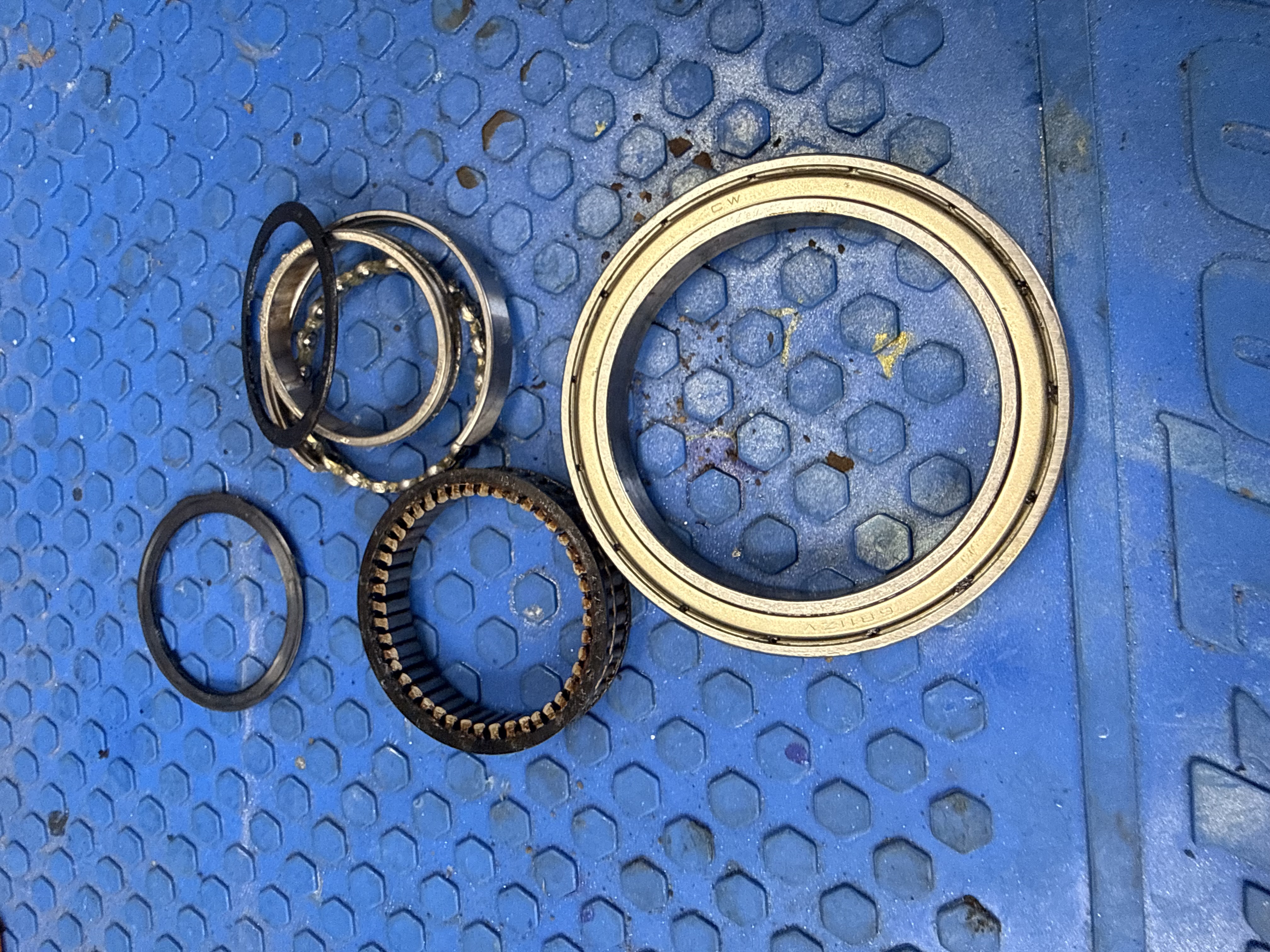 Disassembled motor components arranged on a blue work surface for inspection