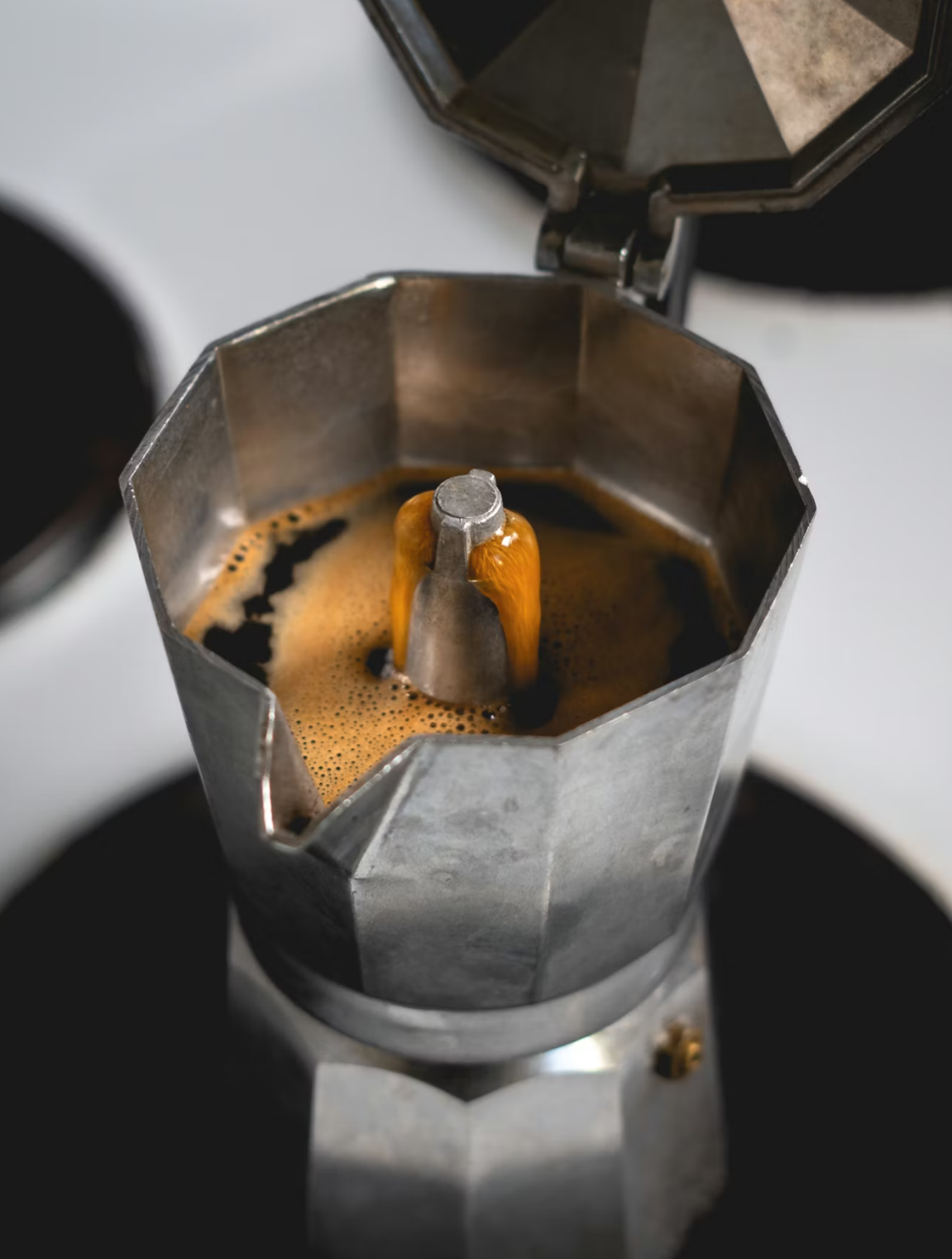 Moka pot brewing fresh espresso with golden crema
