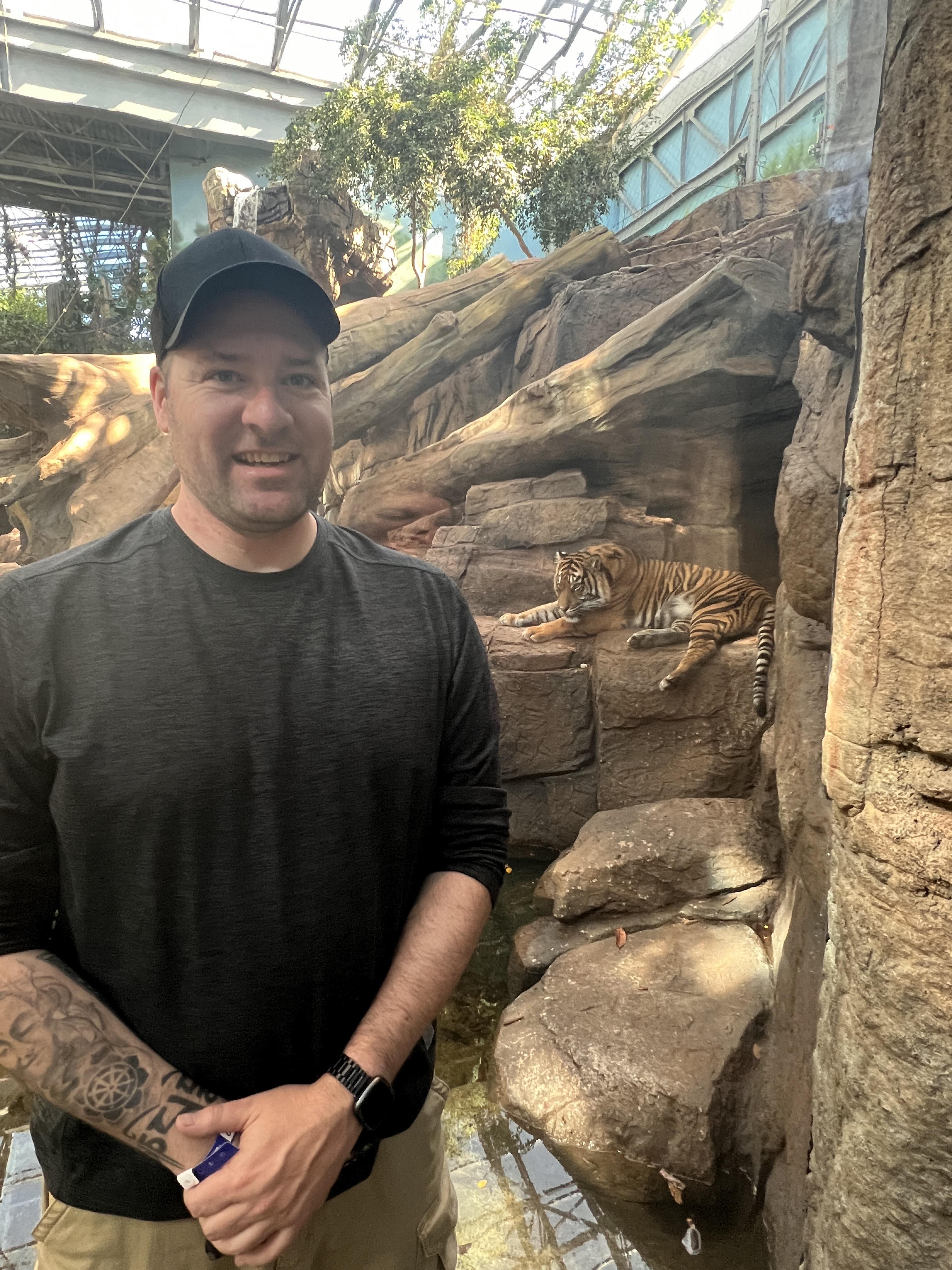 Mike standing in front of a tiger.