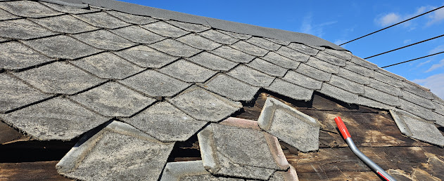 Old asbestos shingles being removed — decay and deterioration visible in old roofing material Lebanon PA