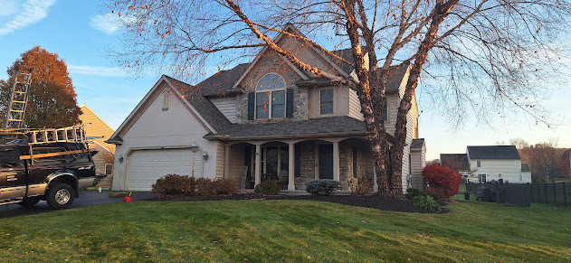 Completed stone accent colonial roof replacement — street view with fresh architectural shingles on brick and stone home