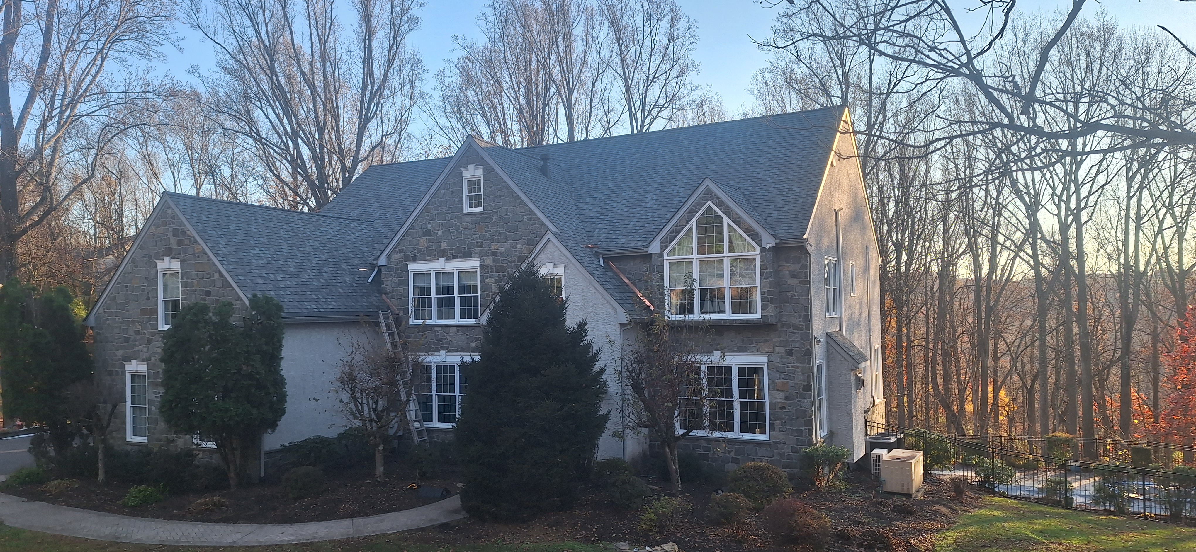 Stone and stucco home with new gray architectural shingles — completed roof replacement in Lebanon PA, multiple dormers and gables
