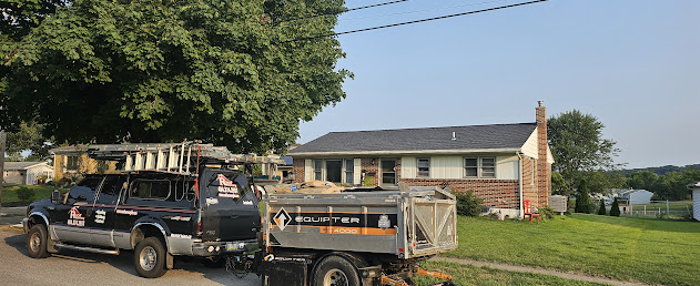 Roof Recovery branded truck and Equipter on-site at brick ranch home — full job site view during re-roof project