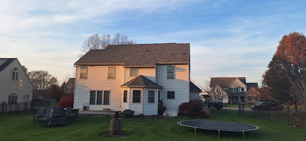 Completed rear view of residential re-roof — fresh architectural shingles on completed home exterior