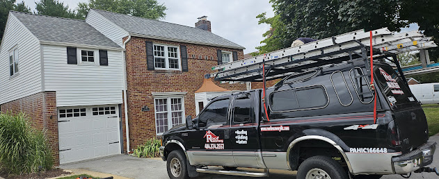 Completed brick colonial full house view with Roof Recovery branded truck — final hero shot after full EPDM and shingle roof replacement