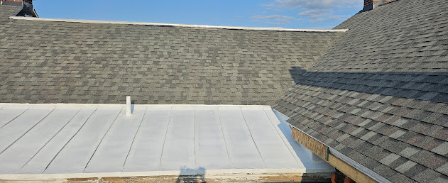 Finished roof — architectural shingles on main pitch and white flat roof coating on low-slope section