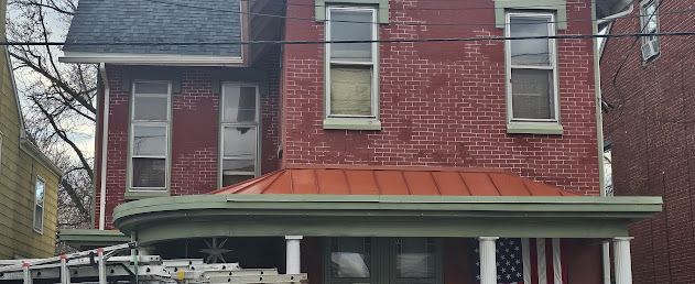 Painted standing seam metal porch roof on Victorian home — clean flat metal roof over curved porch Lebanon PA