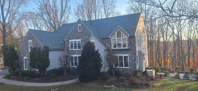 Completed stone facade estate roof replacement — full architectural shingle install across all roof planes, Pennsylvania estate home