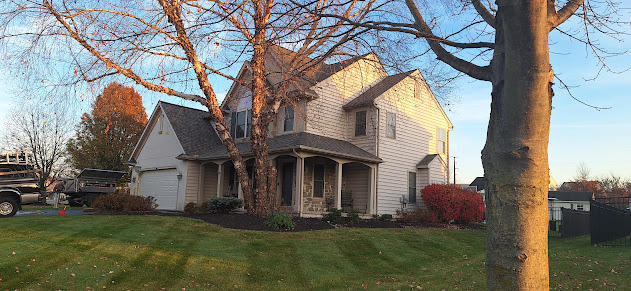 Roof Recovery truck at stone colonial home from second angle — full job site view showing equipment and setup