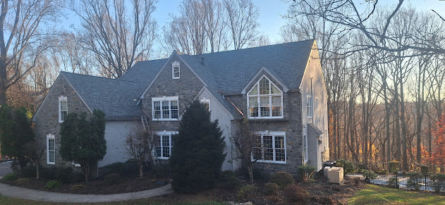 Fresh architectural shingles on stone estate home — first angle of completed roof replacement in Pennsylvania