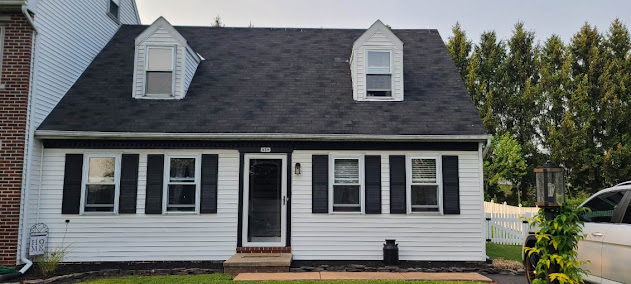 Finished Cape Cod roof front view — new architectural shingles on dormers and main roof, clean curb appeal restored
