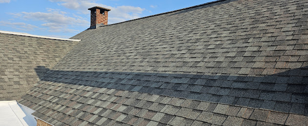 Full roof view of new architectural shingles with chimney — complete shingle install across entire pitch