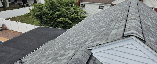 Finished architectural shingles showing EPDM flat section and shingle pitch transition on brick colonial