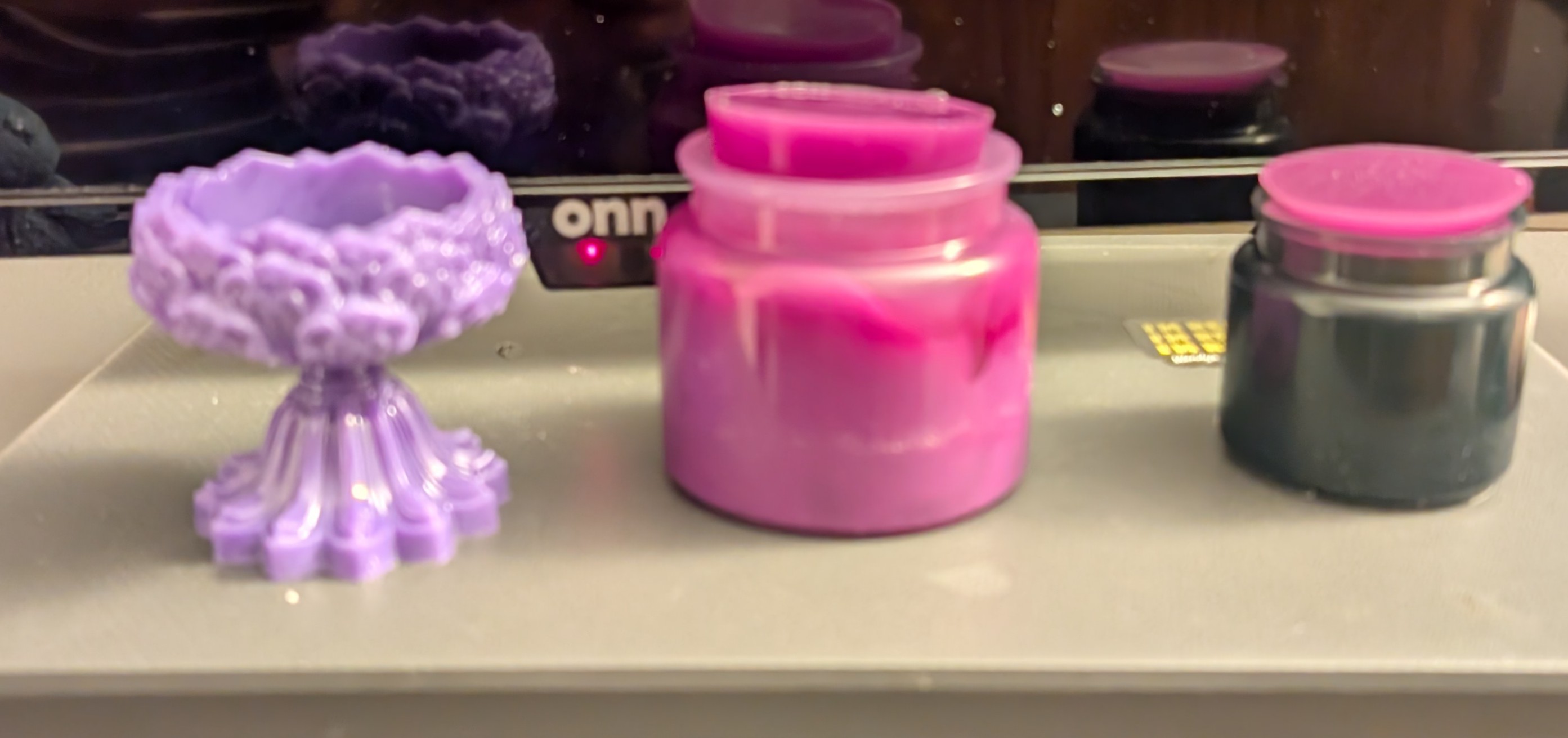 Handmade purple ornate candle holder, pink resin jar, and dark jar with pink lid