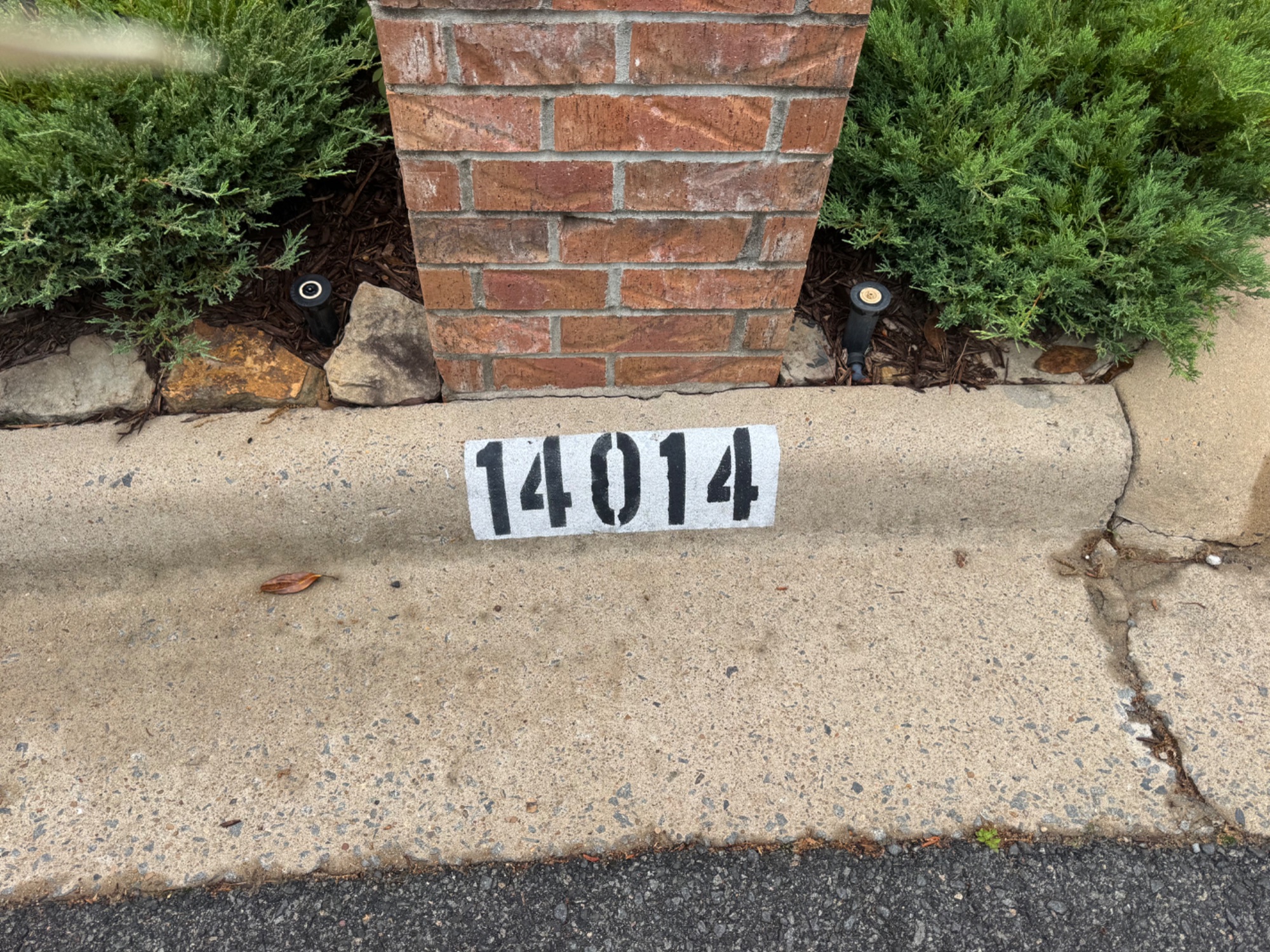 CurbMark — address 14014 painted on curb next to brick mailbox pillar with landscaping