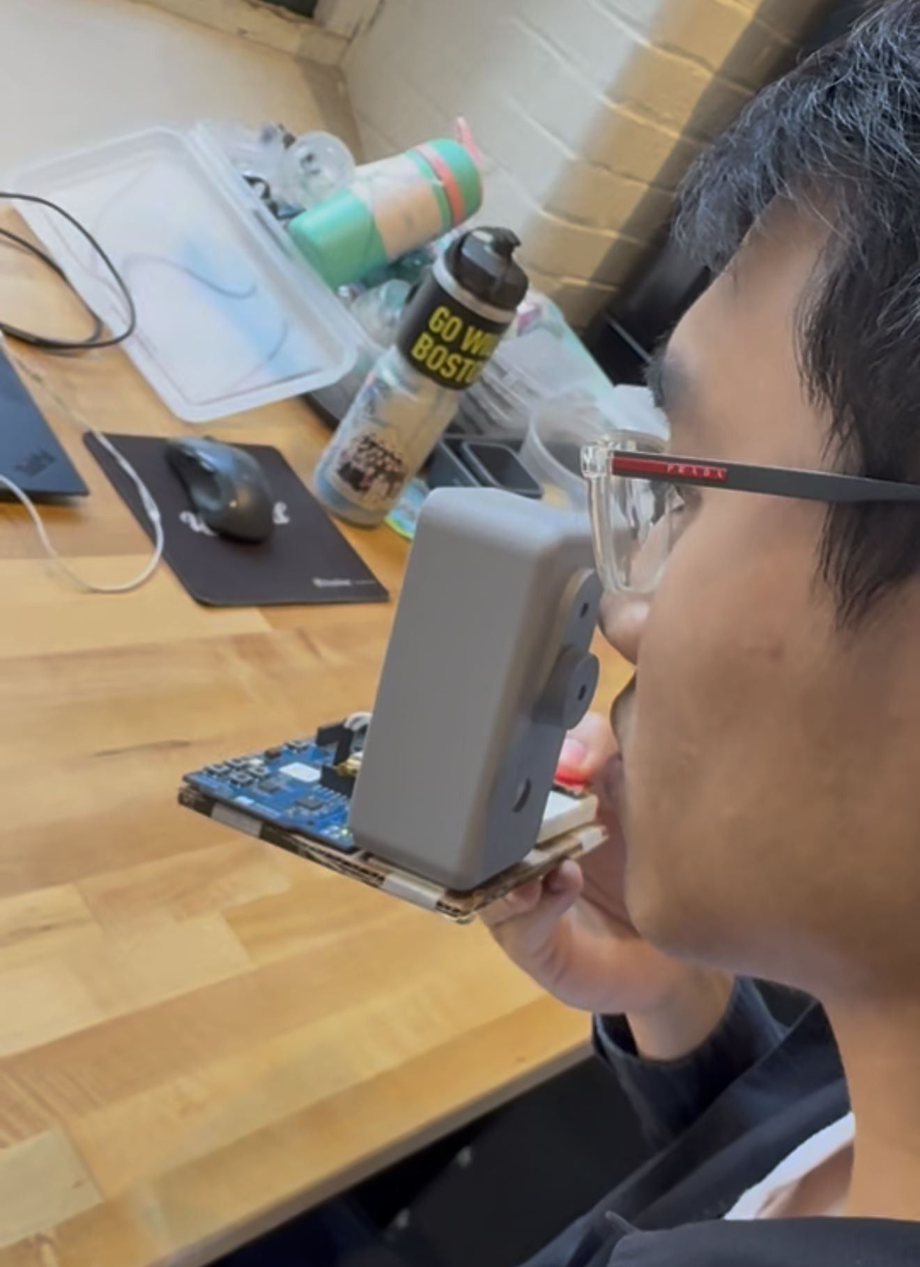 User testing prototype at workbench with exposed PCB