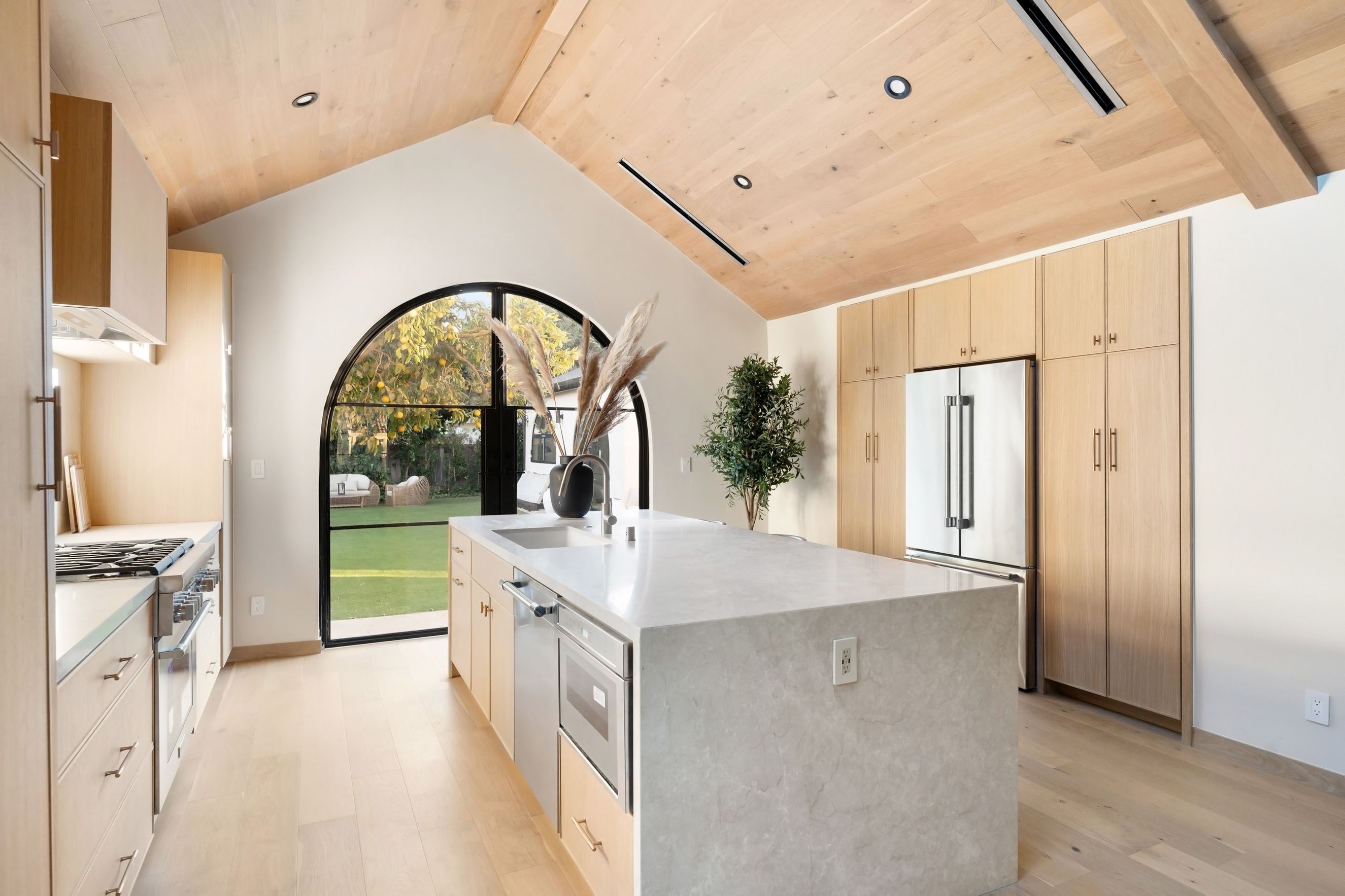 Modern luxury indoor kitchen with arch window and concrete countertops &mdash; Mesa Precast custom GFRC countertops for modern luxury kitchens