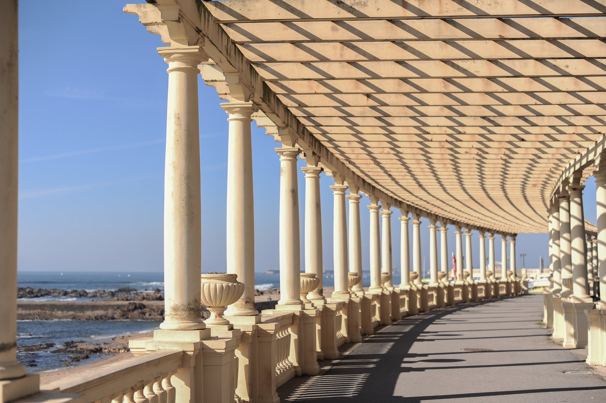 Seaside colonnade with architectural columns and pergola overhead