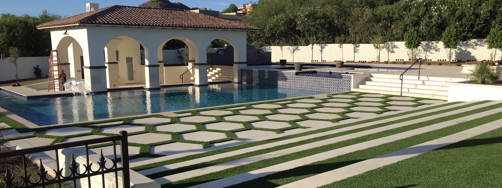 Geometric pool pavers with arched pool house