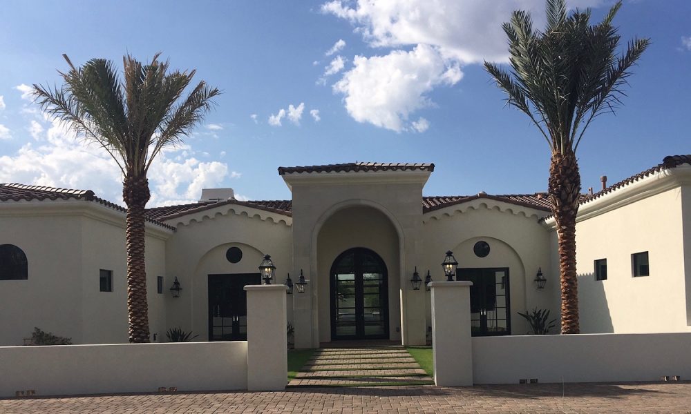Mediterranean residential home showcasing decorative cast stone cornices and scalloped moldings along roofline