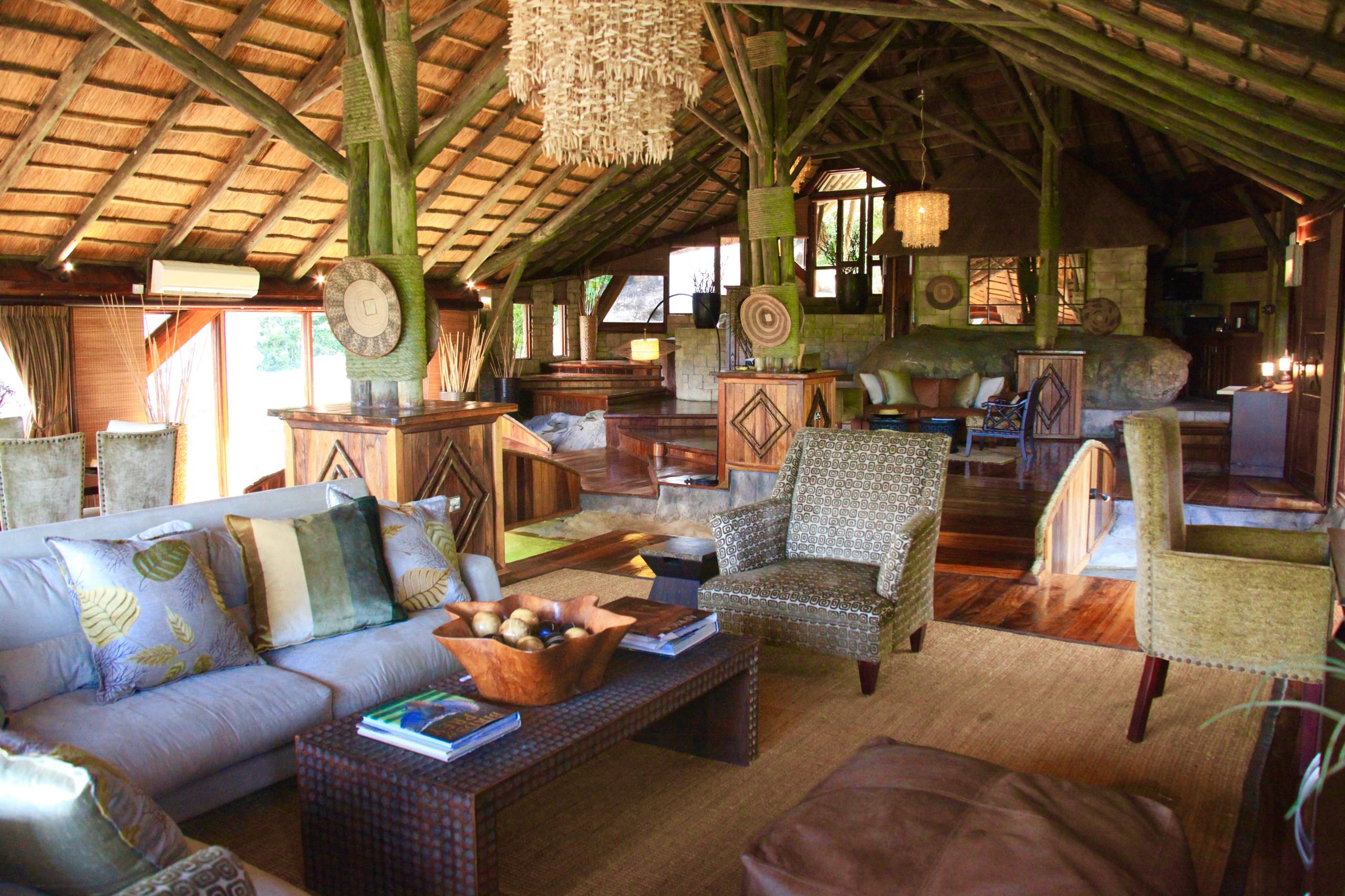 Serena Mivumo lounge — thatched-roof bar with hardwood furniture and warm lighting