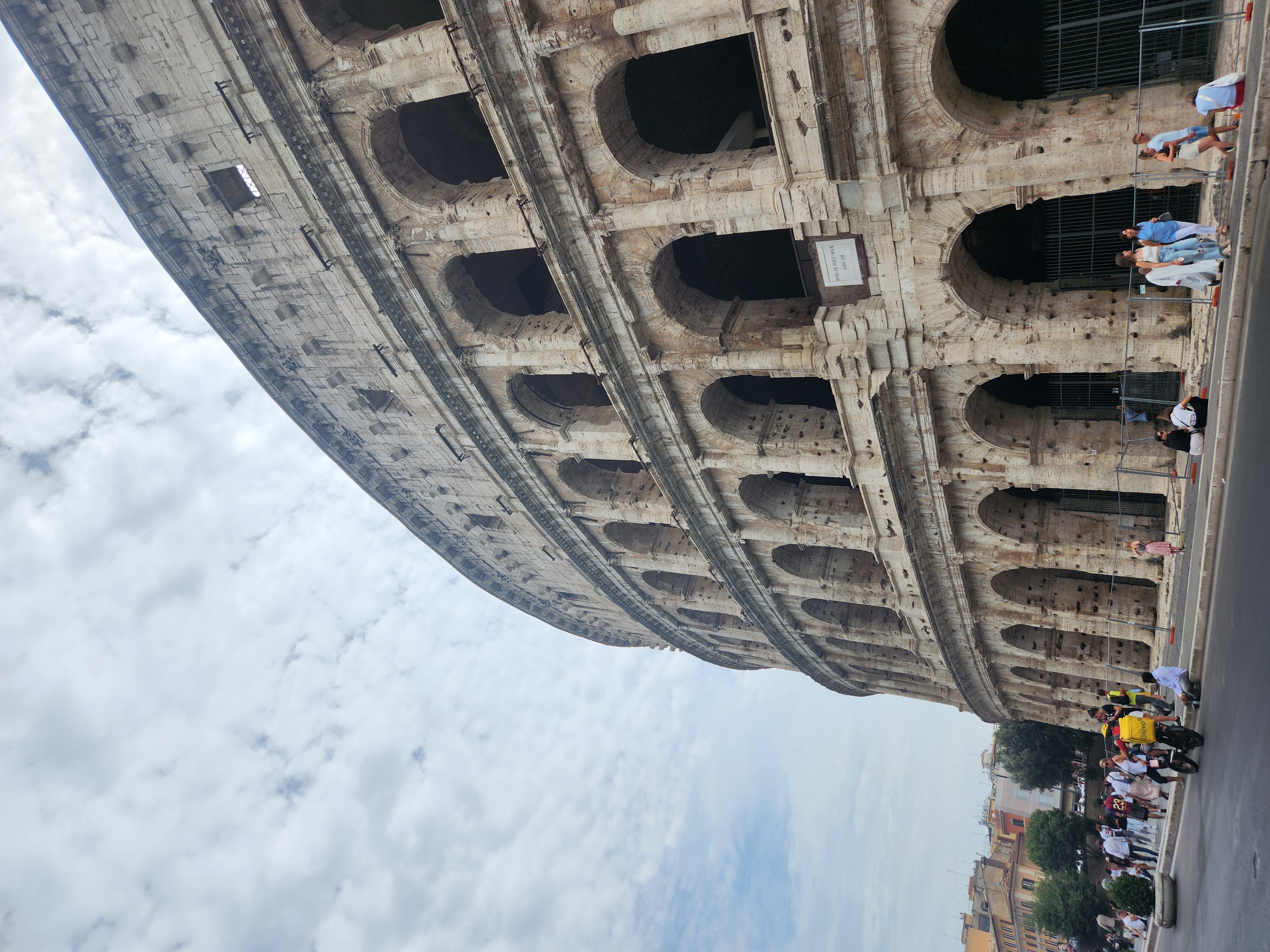 The Colosseum rising above a busy street in Rome.