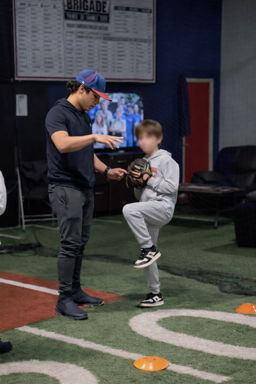 Coach Silvio instructing a young player on pitching mechanics