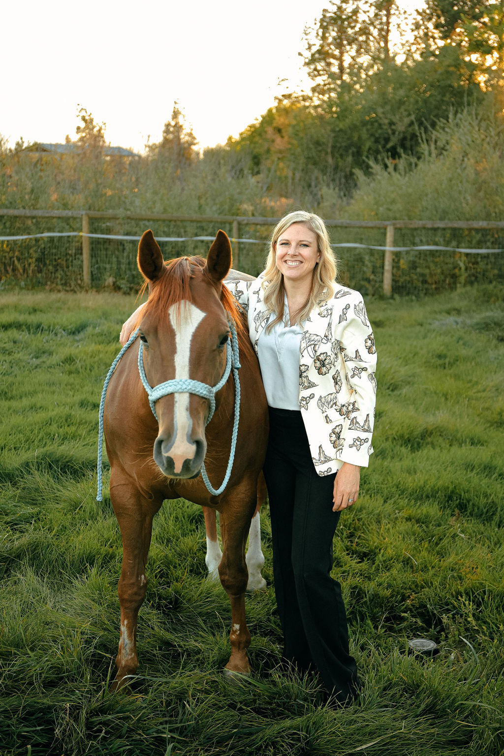 Christina with her horse, smiling in a green field