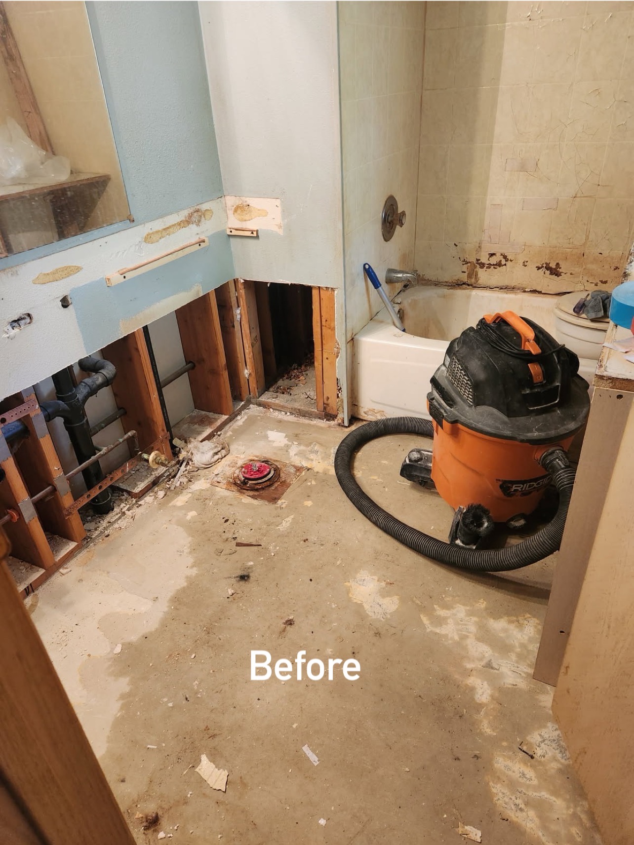 Bathroom gutted to bare subfloor — before water restoration