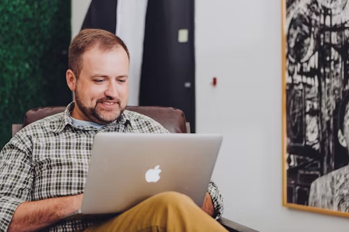 First-time homebuyer smiling while using HomeLeap tools on his laptop