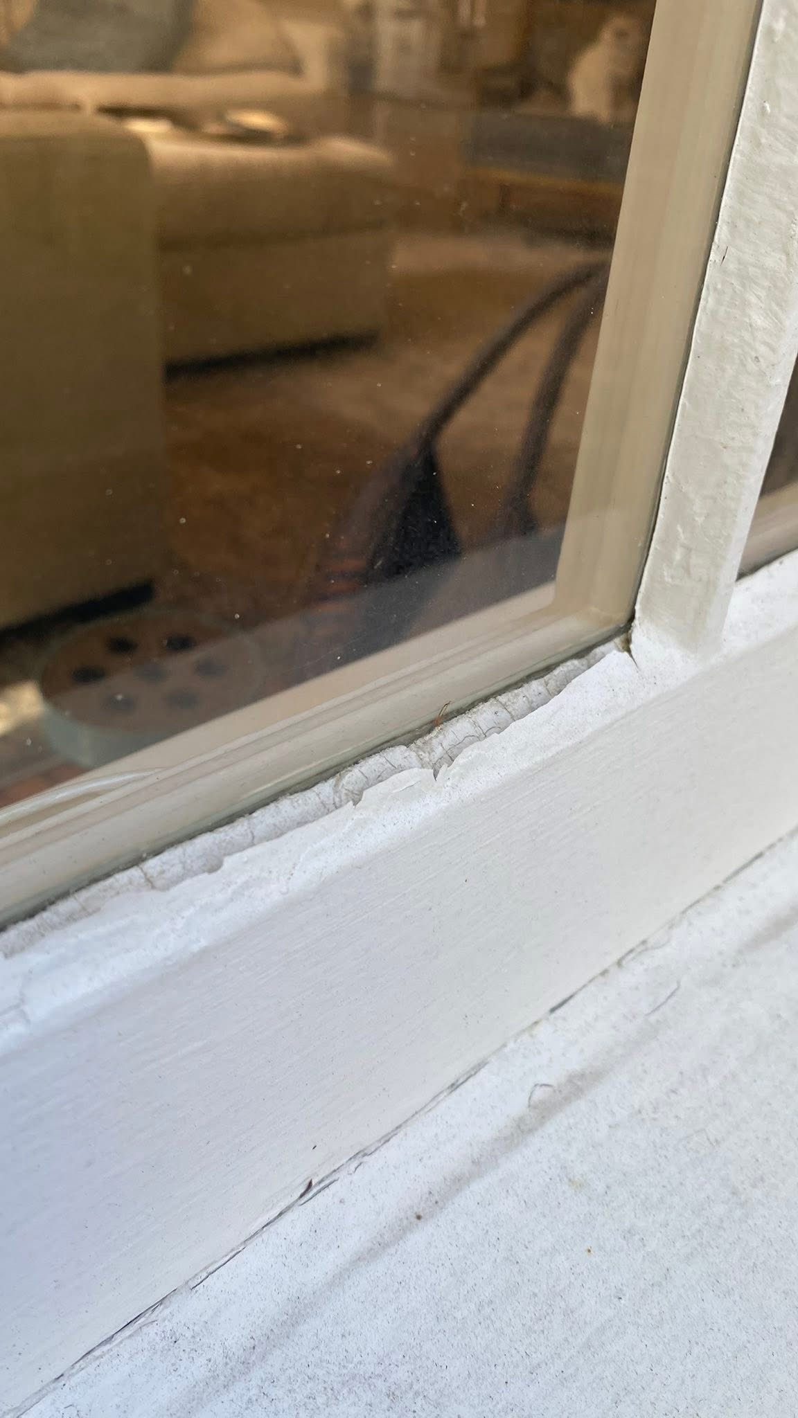 Glazing compound failing at the glass joint, with visible gaps and deterioration